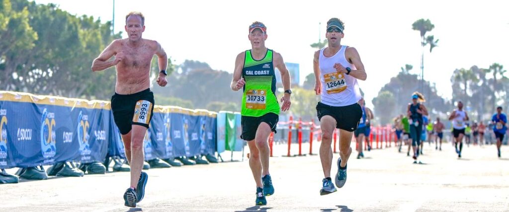 shirtless man and two runners